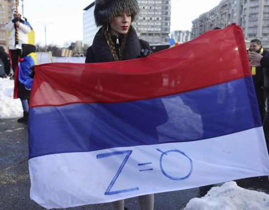 Steagul Rusiei cu simbolul razboiului in Ucraina fluturat la miting pro Calin Georgescu